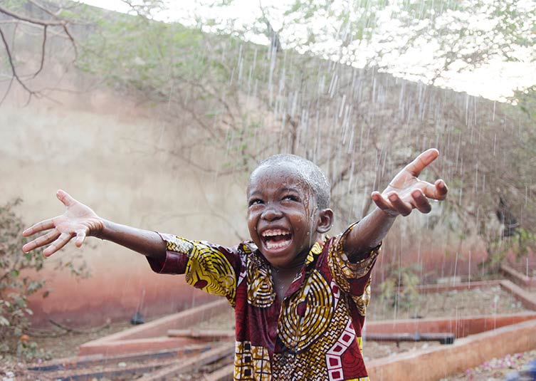 Child under the rain in Mali (photo by Riccardo Mayer).